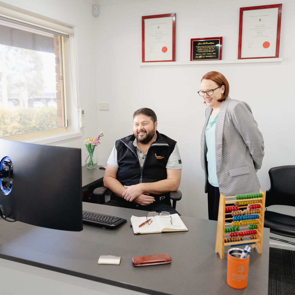 Jim McCredden and Alecia Fry smiling while working together at Golden Plains Accountants office